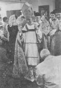 Archbishop Lefebvre blesses as he walks down the aisle