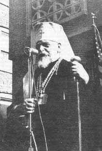 Cardinal Slipyi speaks into a microphone before the United States flag