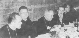 Archbishop Lefevbre, bishops and priests sit at a table at the reception