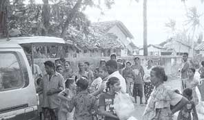 villagers get bags of food from truck