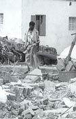 man inspects remains of his house